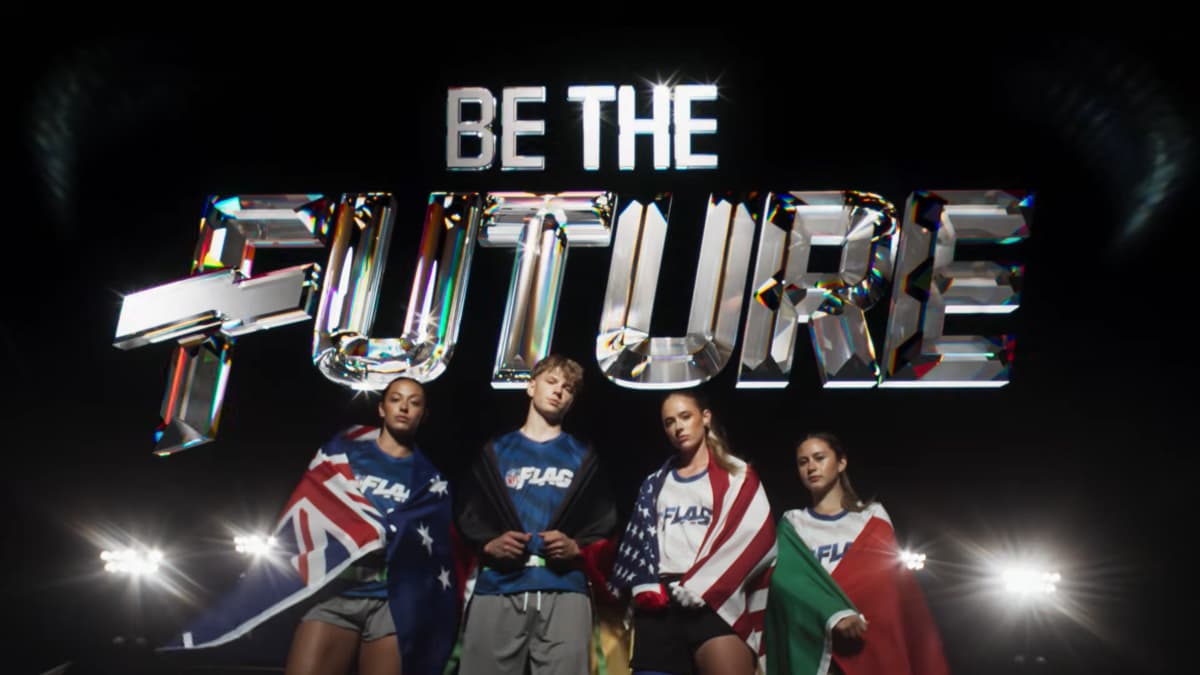 Four athletes in sports attire hold national flags under the text "Be The Future" in bold, illuminated letters.