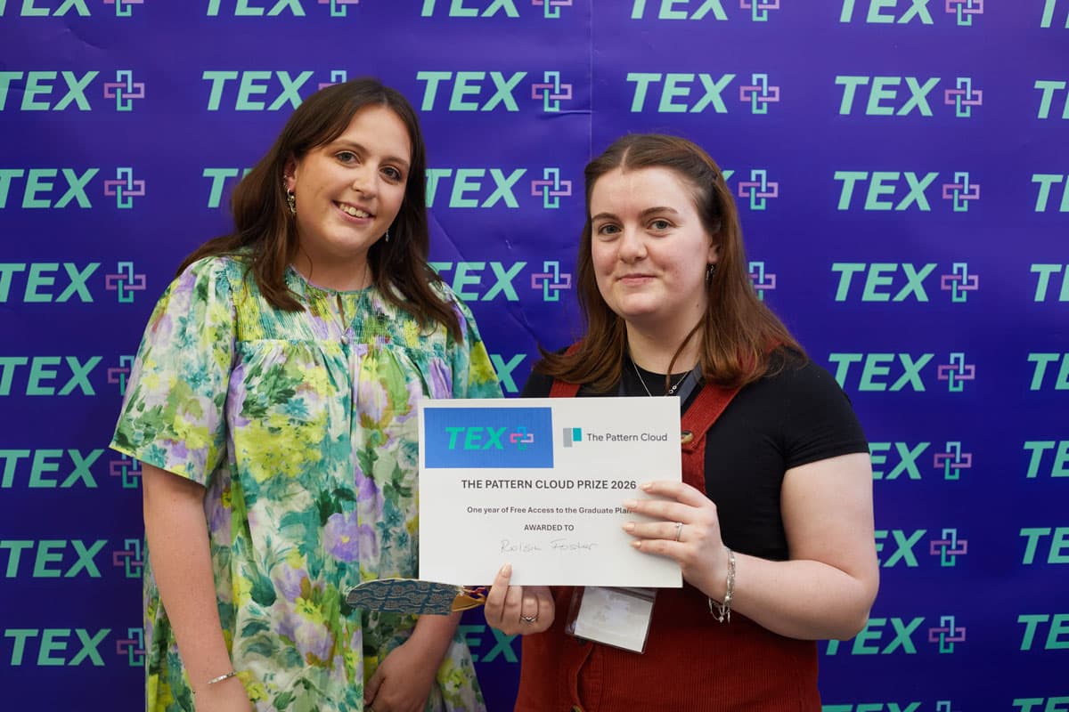 Two people smiling, one holding a certificate that reads "The Pattern Cloud Prize 2026" in front of a blue "TEX" branded backdrop.